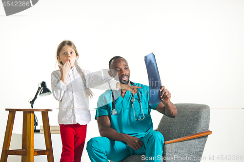 Image of Young african male pediatrician explaining X-ray to child