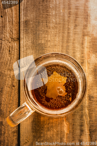 Image of French beer concept, France silhouette on foam in beer glass on wooden table.