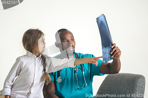 Image of Young african male pediatrician explaining X-ray to child