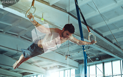 Image of The sportsman during difficult exercise, sports gymnastics