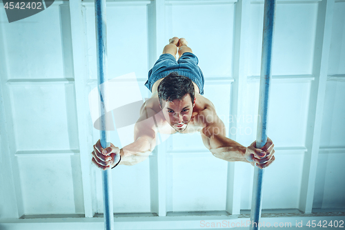 Image of The sportsman during difficult exercise, sports gymnastics