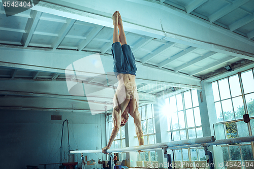 Image of The sportsman during difficult exercise, sports gymnastics