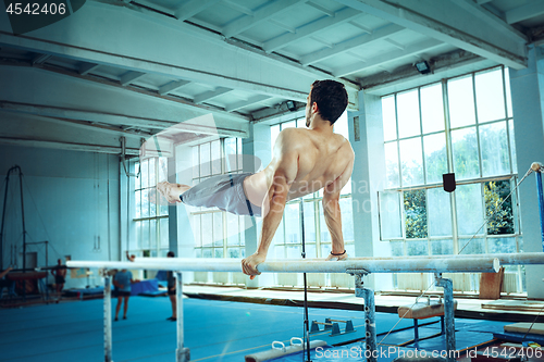 Image of The sportsman during difficult exercise, sports gymnastics