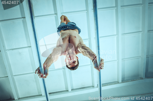 Image of The sportsman during difficult exercise, sports gymnastics