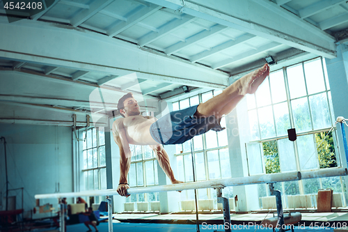 Image of The sportsman during difficult exercise, sports gymnastics