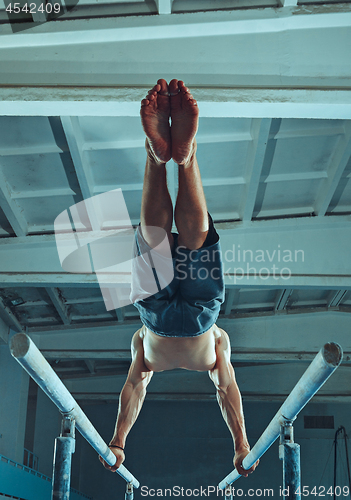 Image of The sportsman during difficult exercise, sports gymnastics