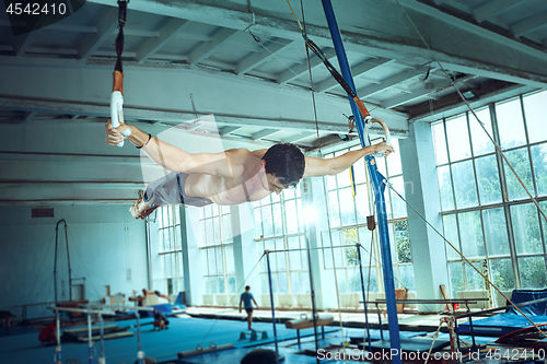 Image of The sportsman during difficult exercise, sports gymnastics