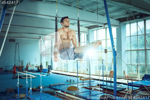 Image of The sportsman during difficult exercise, sports gymnastics