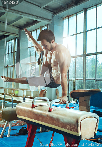 Image of The sportsman during difficult exercise, sports gymnastics