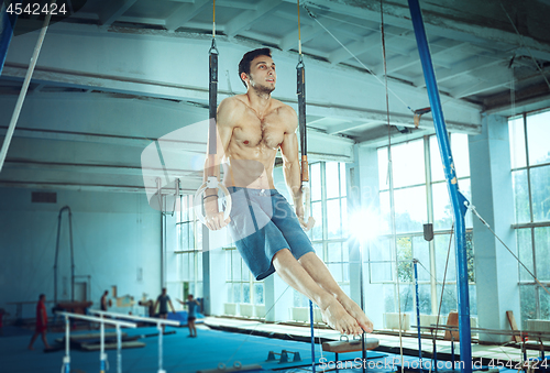 Image of The sportsman during difficult exercise, sports gymnastics