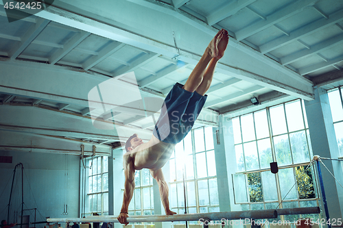 Image of The sportsman during difficult exercise, sports gymnastics