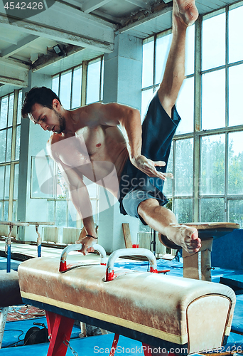 Image of The sportsman during difficult exercise, sports gymnastics