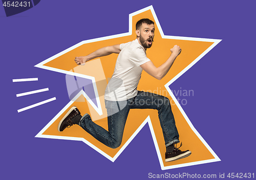 Image of Freedom in moving. handsome young man jumping against orange background