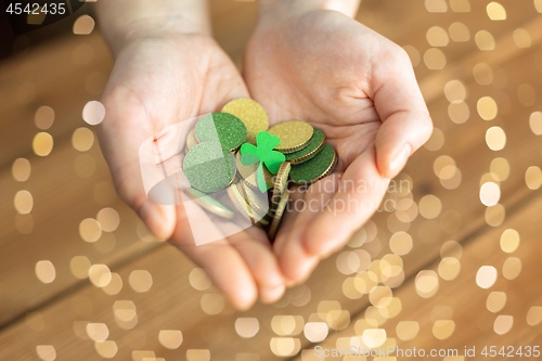 Image of hands with golden coins and shamrock leaf