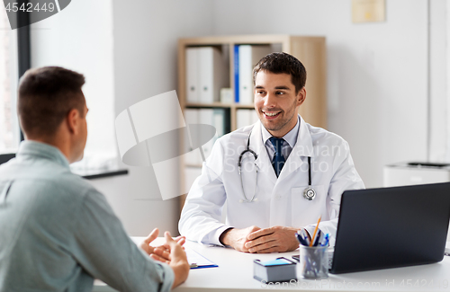 Image of doctor with laptop and male patient at hospital