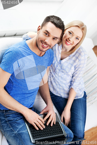 Image of happy couple with laptop computer at home