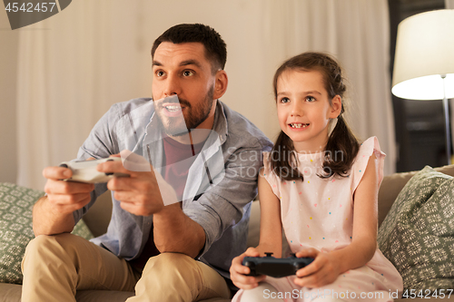 Image of father and daughter playing video game at home