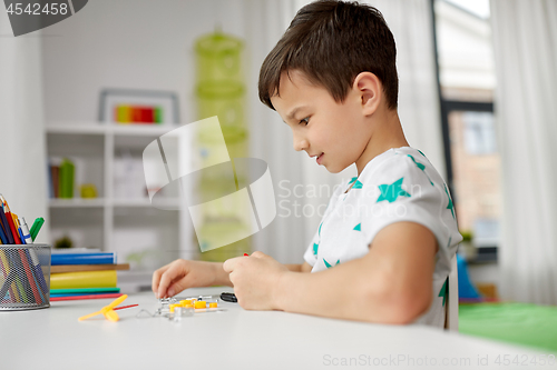 Image of little boy playing with building kit at home