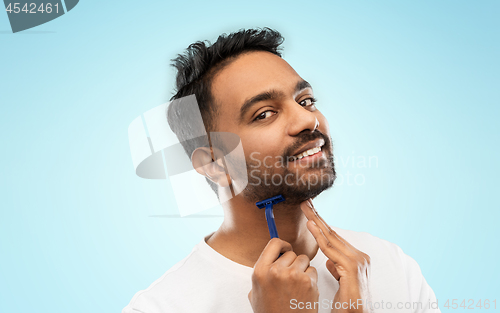 Image of indian man shaving beard with razor blade