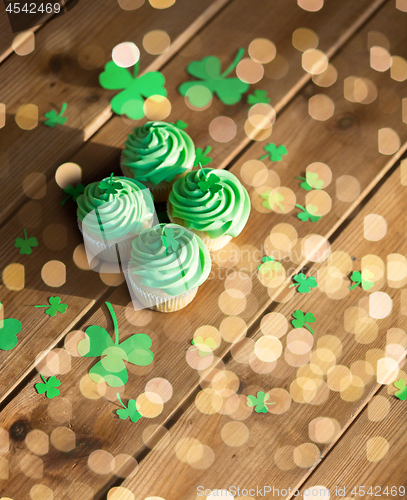 Image of green cupcakes and shamrock on wooden table