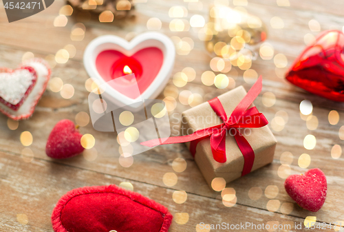 Image of christmas gift, heart shaped decorations, candle