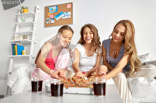 Image of happy friends or teen girls eating pizza at home