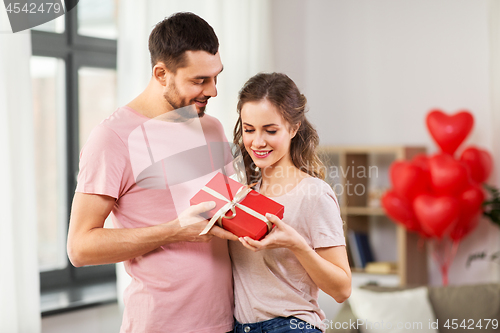 Image of couple with gift box on valentines day at home