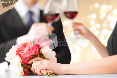 Image of close up of engaged couple drinking red wine