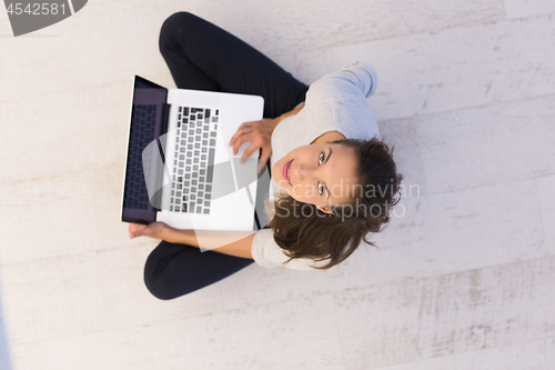 Image of women using laptop computer on the floor top view