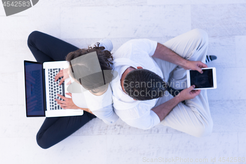 Image of couple using tablet and laptop computers top view
