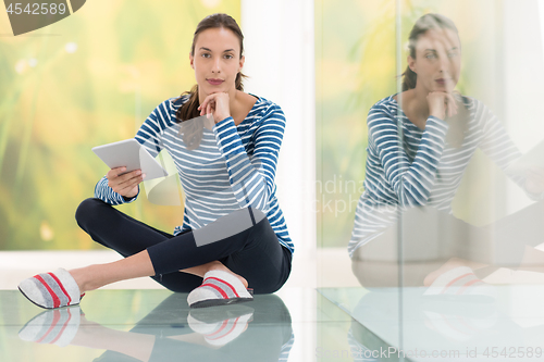 Image of young women using tablet computer on the floor