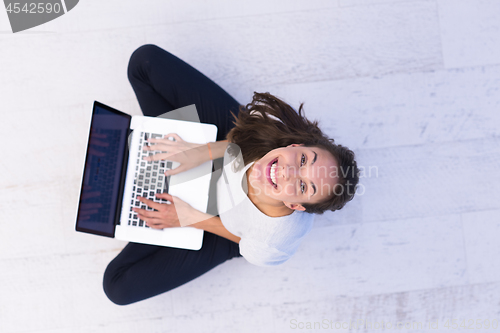 Image of women using laptop computer on the floor top view