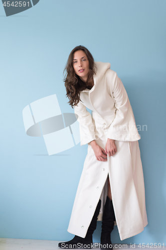 Image of woman in a white coat with hood isolated on blue background