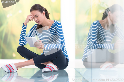 Image of young women using tablet computer on the floor