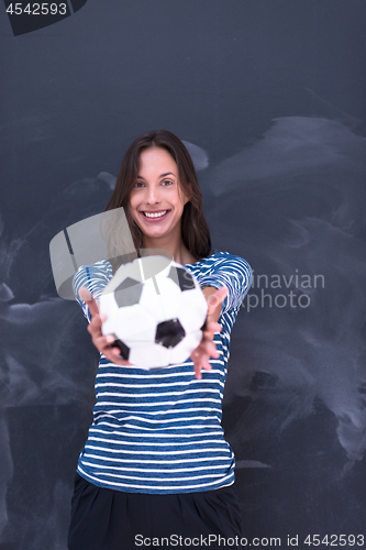 Image of woman holding a soccer ball in front of chalk drawing board