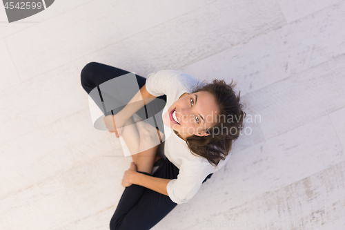 Image of top view of young woman sitting on the floor