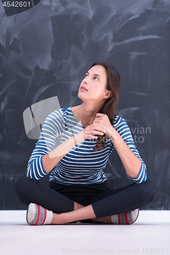 Image of woman sitting in front of chalk drawing board