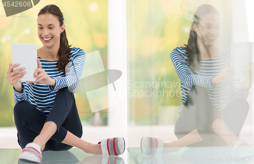 Image of young women using tablet computer on the floor