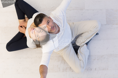 Image of couple sitting with back to each other on floor