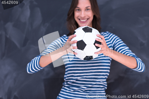 Image of woman holding a soccer ball in front of chalk drawing board