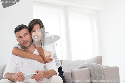 Image of happy couple using mobile phone at home