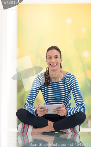 Image of young women using tablet computer on the floor