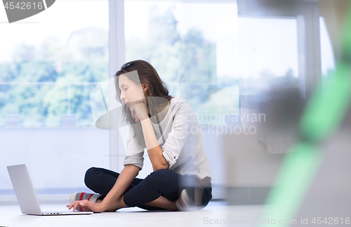 Image of young women using laptop computer on the floor