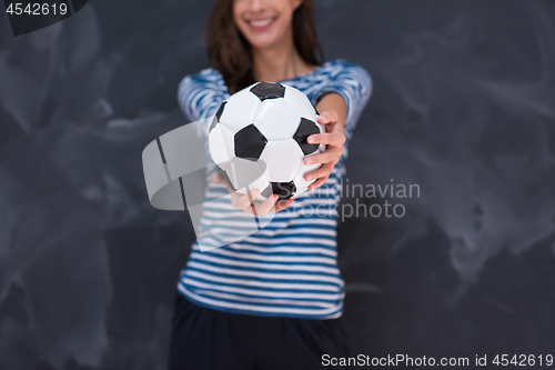 Image of woman holding a soccer ball in front of chalk drawing board
