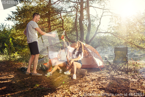 Image of Party, camping of men and women group at forest. They relaxing