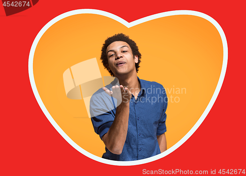 Image of The happy business man standing and smiling against orange background.