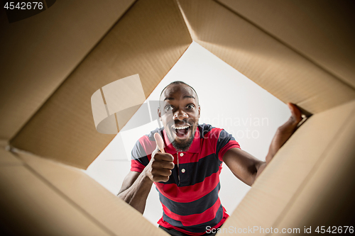 Image of Man unpacking and opening carton box and looking inside