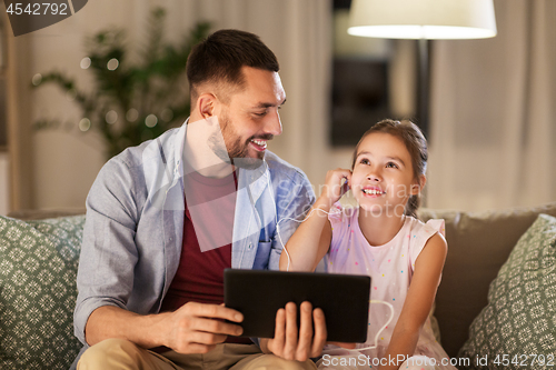 Image of father and daughter listening to music on tablet