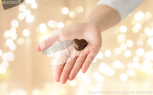 Image of close up of hand with heart shaped chocolate candy