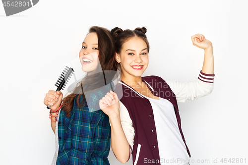 Image of teenage girls singing to hairbrush and having fun